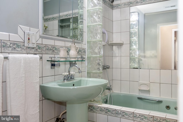 bathroom with tile walls and a relaxing tiled tub