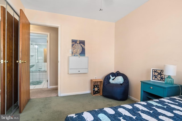 bedroom with ensuite bathroom and carpet flooring