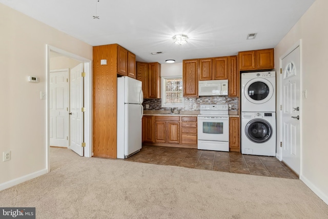 kitchen featuring tasteful backsplash, carpet flooring, sink, stacked washer and clothes dryer, and white appliances