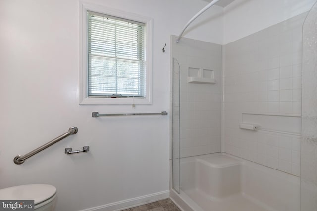 bathroom with tiled shower and toilet