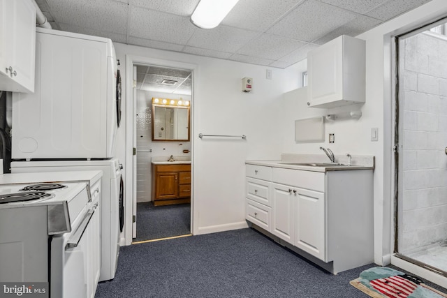 kitchen featuring sink, white cabinetry, stacked washer and clothes dryer, white range with electric stovetop, and dark colored carpet