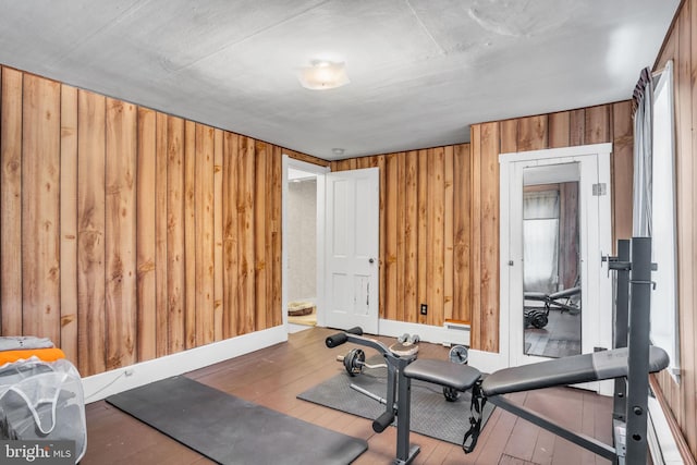 workout room featuring wood-type flooring and wooden walls