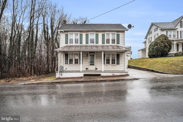 view of front of house with covered porch and a front lawn