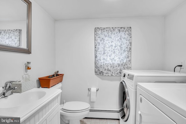 bathroom with independent washer and dryer, vanity, toilet, and a baseboard heating unit