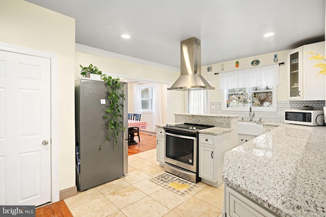 1034 Excelsior Dr, Upper Chichester, PA 19014 - kitchen featuring white cabinetry, island exhaust hood, appliances with stainless steel finishes, and light stone counters