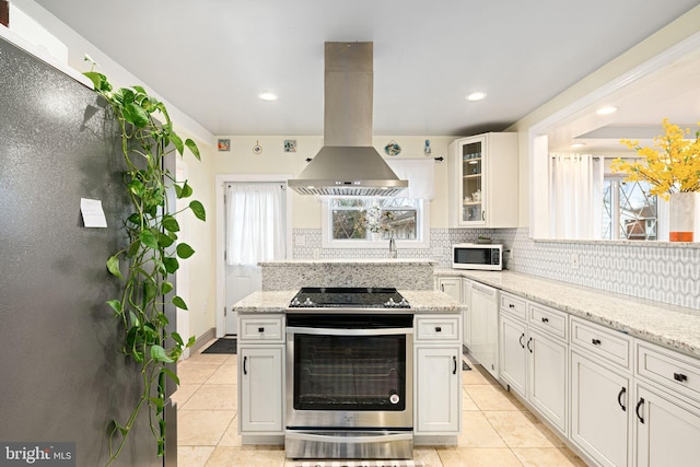 1034 Excelsior Dr, Upper Chichester, PA 19014 - kitchen with white cabinetry, backsplash, stainless steel range, island range hood, and light stone countertops