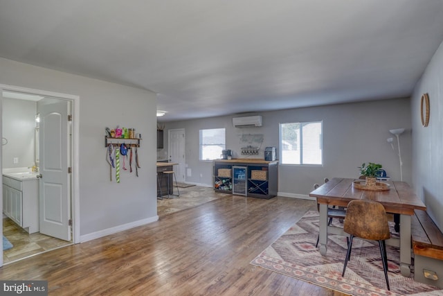 dining room featuring light hardwood / wood-style floors and an AC wall unit