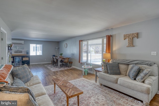 living room featuring hardwood / wood-style flooring, a wealth of natural light, and a wall mounted AC