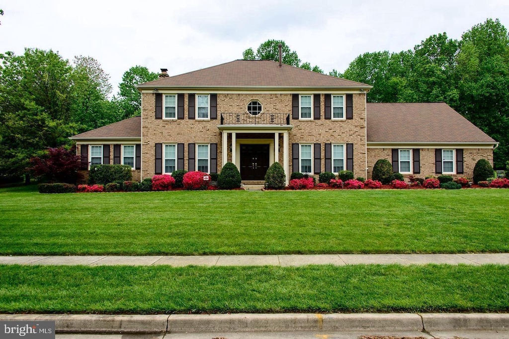 colonial-style house with a front lawn