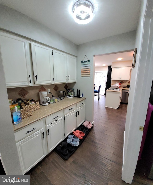 kitchen with dishwasher, white cabinetry, dark wood-type flooring, and light stone counters