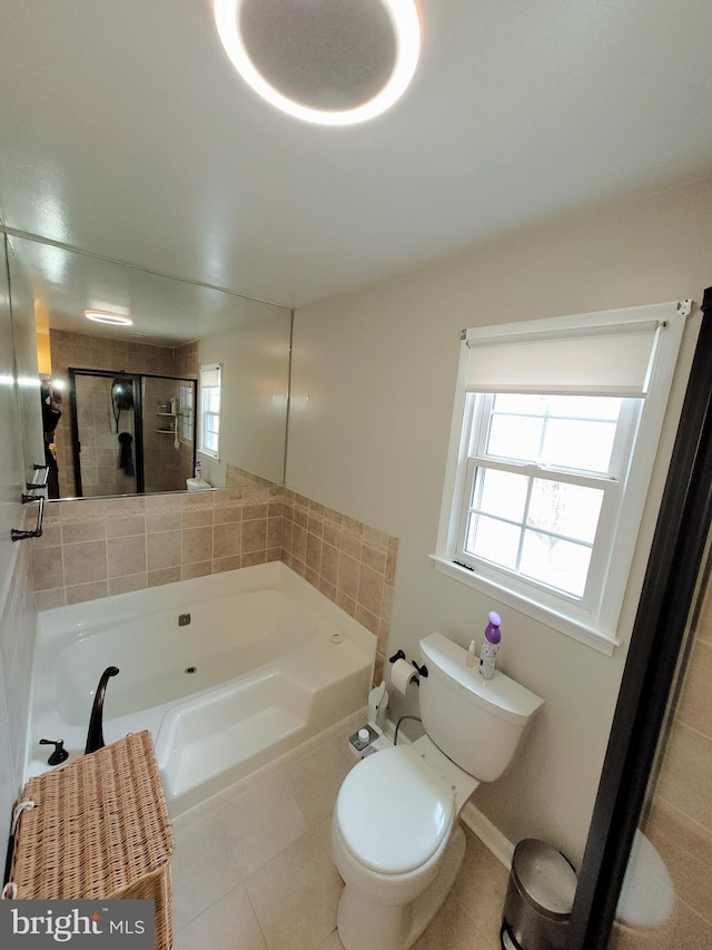 bathroom featuring a washtub, tile patterned floors, and toilet