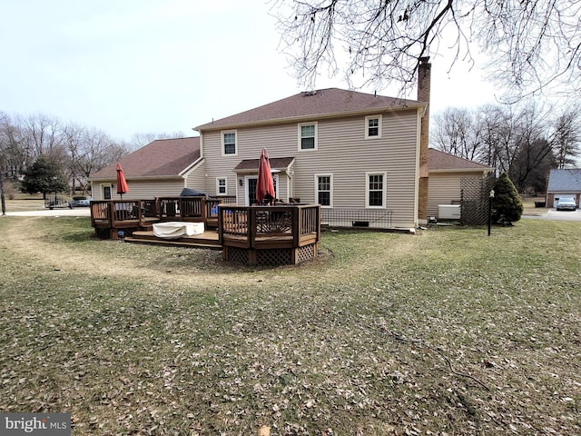 rear view of property with a deck and a lawn