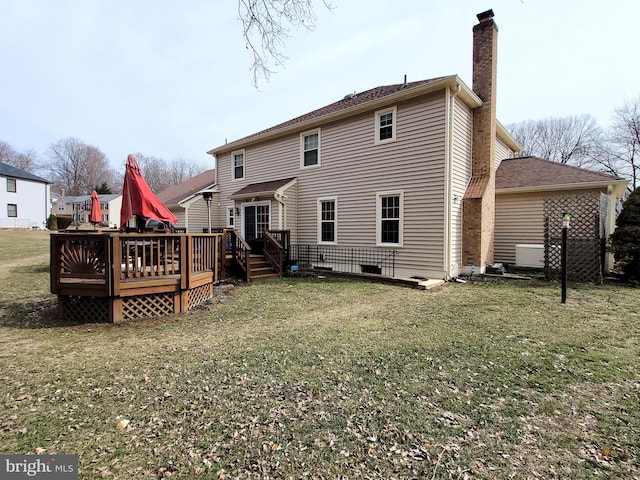 rear view of house with a yard and a wooden deck