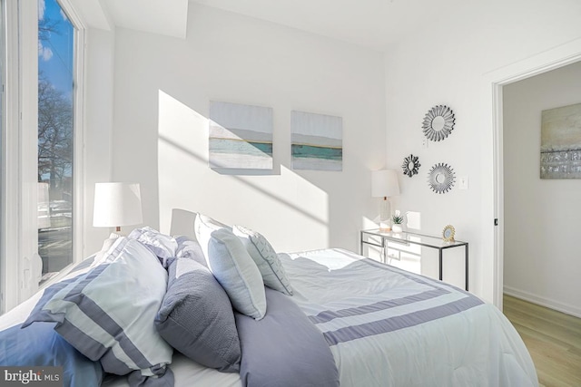 bedroom with multiple windows and light hardwood / wood-style floors