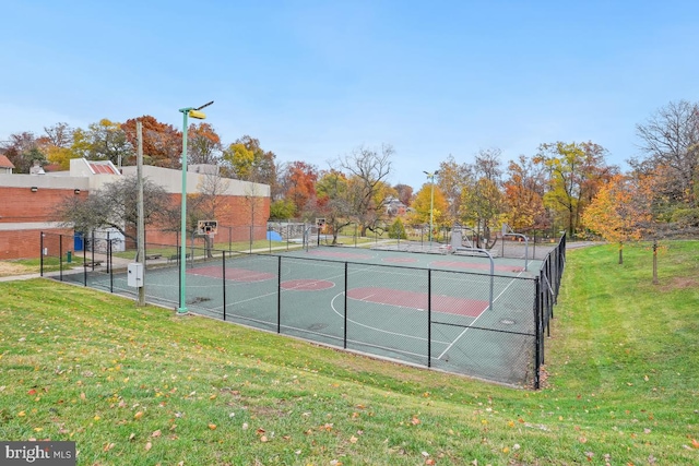 view of sport court with a lawn