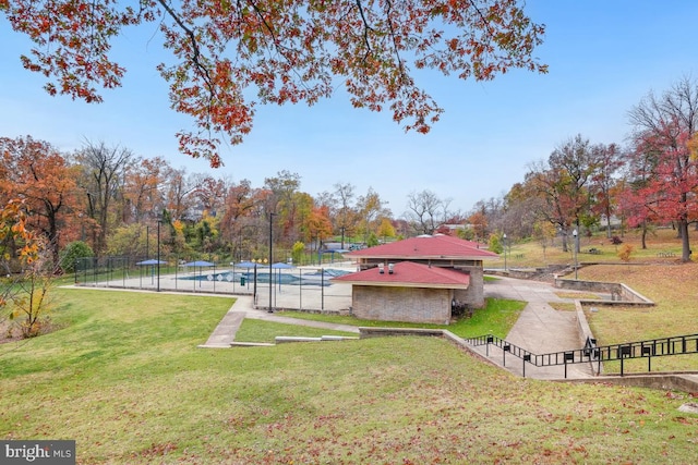 surrounding community with a pool and a lawn