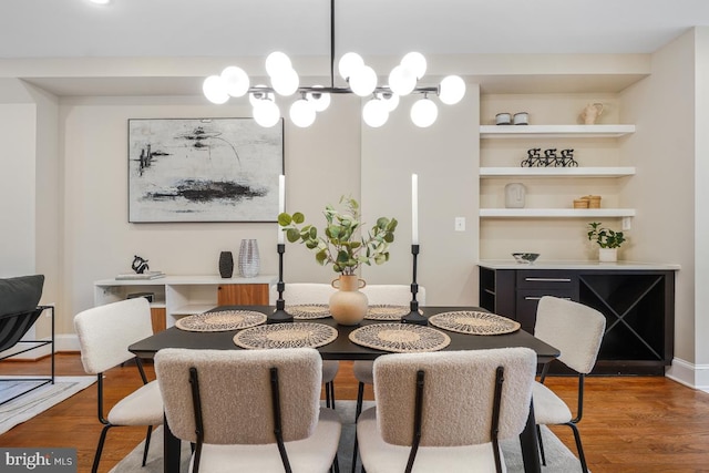 dining area with wood-type flooring and an inviting chandelier