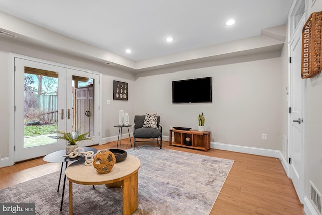 living area featuring french doors and light hardwood / wood-style flooring