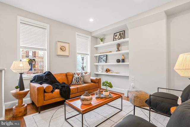 living room with light hardwood / wood-style floors and built in features