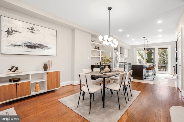 dining area with hardwood / wood-style flooring and a chandelier