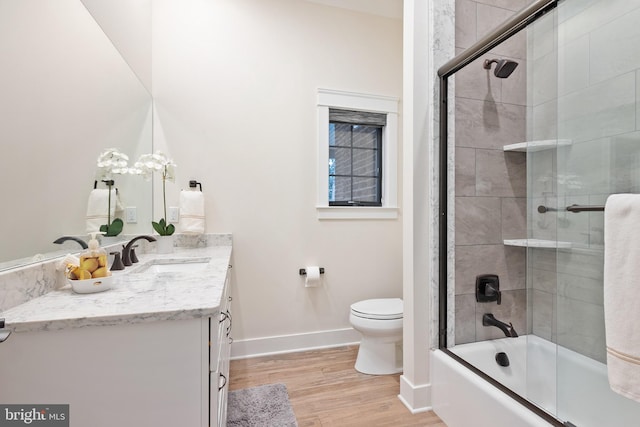 full bathroom with enclosed tub / shower combo, vanity, toilet, and wood-type flooring