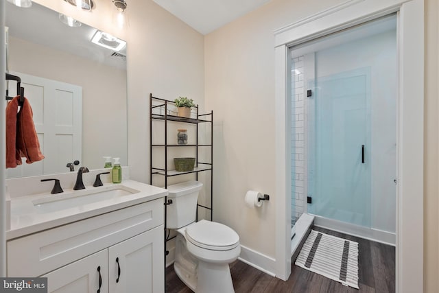 bathroom with vanity, wood-type flooring, toilet, and a shower