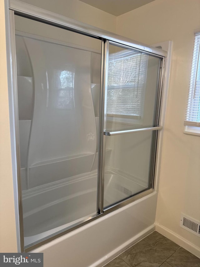 full bath featuring baseboards, visible vents, and combined bath / shower with glass door