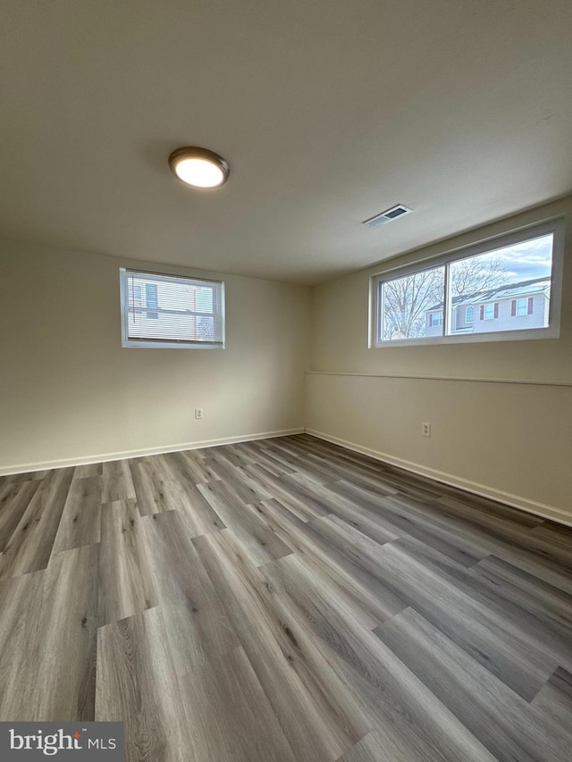 unfurnished room with visible vents, baseboards, and wood finished floors