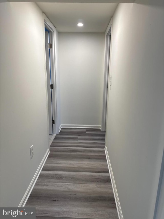 hallway featuring recessed lighting, wood finished floors, and baseboards