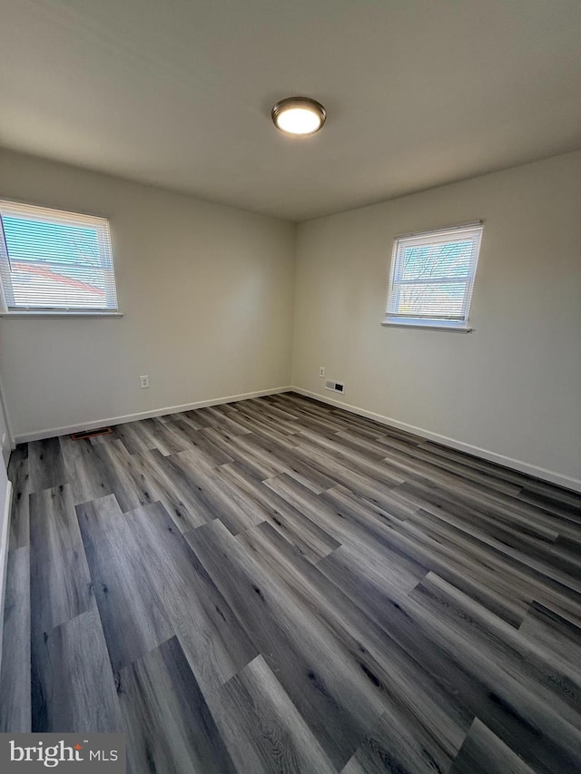 empty room with baseboards and wood finished floors