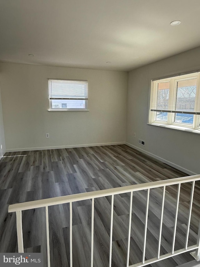 empty room with visible vents, baseboards, and wood finished floors