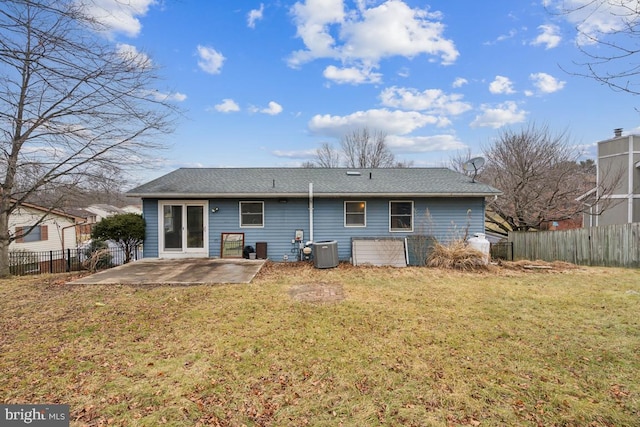 back of property featuring central AC unit, a patio area, and a lawn