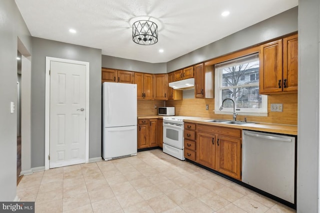 kitchen featuring tasteful backsplash, sink, and white appliances