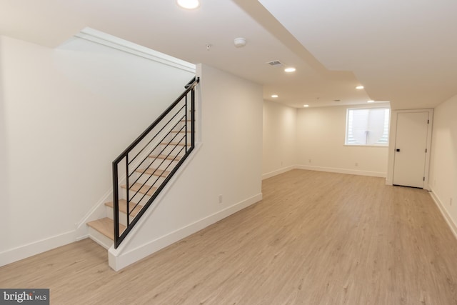 basement with baseboards, light wood-style flooring, and recessed lighting