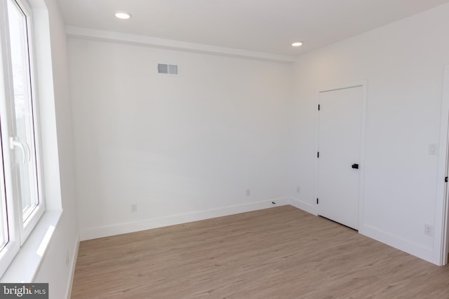 unfurnished room with recessed lighting, visible vents, light wood-style flooring, and baseboards