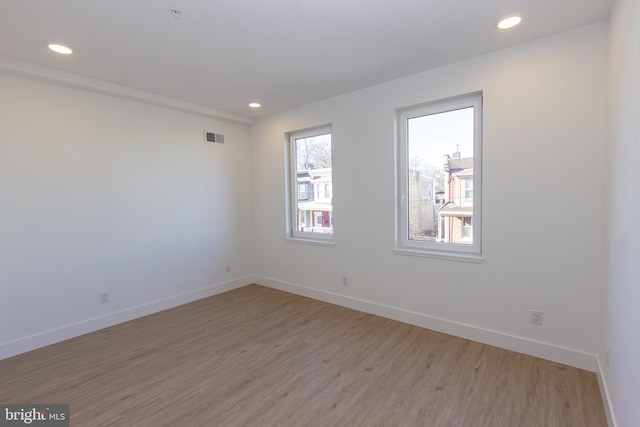 unfurnished room featuring recessed lighting, light wood-type flooring, visible vents, and baseboards