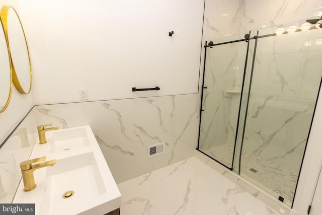 full bath featuring marble finish floor, a marble finish shower, tile walls, and vanity