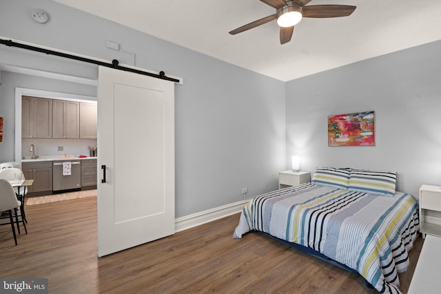 bedroom with a barn door, dark wood-type flooring, and sink