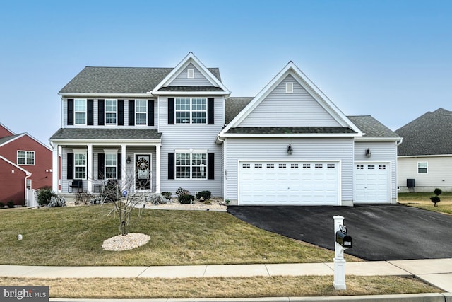 view of front of property featuring a porch, a garage, and a front lawn