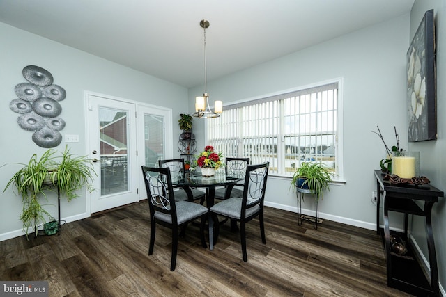 dining room with dark wood-type flooring and a chandelier