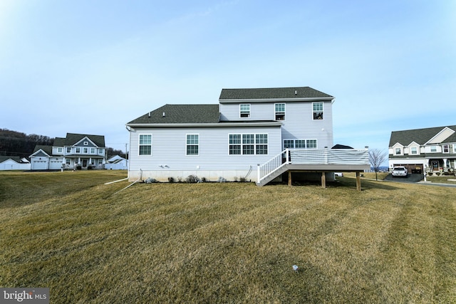 rear view of property with a yard and a deck