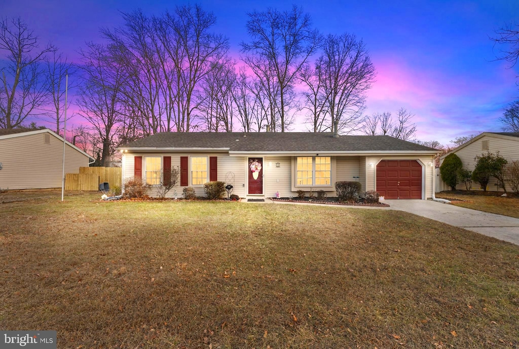 ranch-style house featuring a yard and a garage