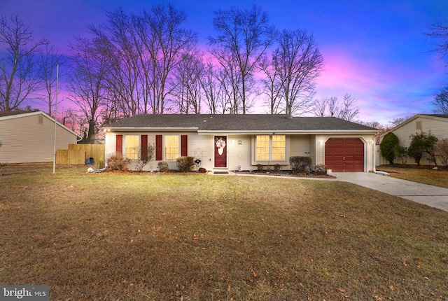 ranch-style house featuring a yard and a garage