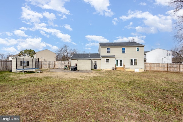 back of property featuring a trampoline, a yard, and a patio area