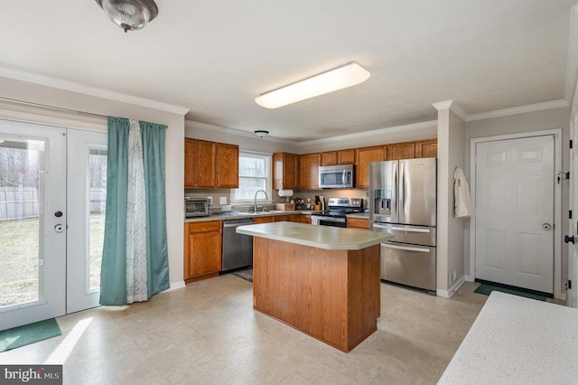 kitchen featuring ornamental molding, appliances with stainless steel finishes, sink, and a kitchen island