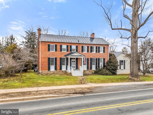 colonial-style house featuring a front lawn