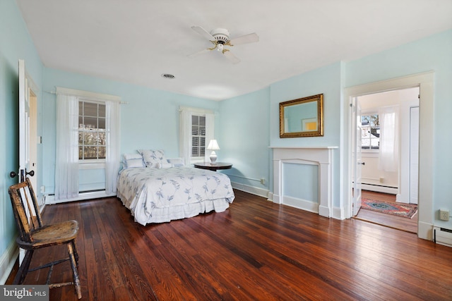 bedroom with baseboard heating and dark hardwood / wood-style floors