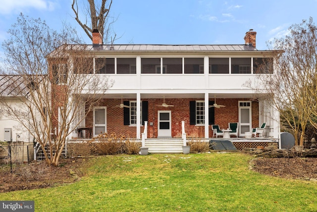 view of front facade featuring a sunroom, ceiling fan, and a front lawn