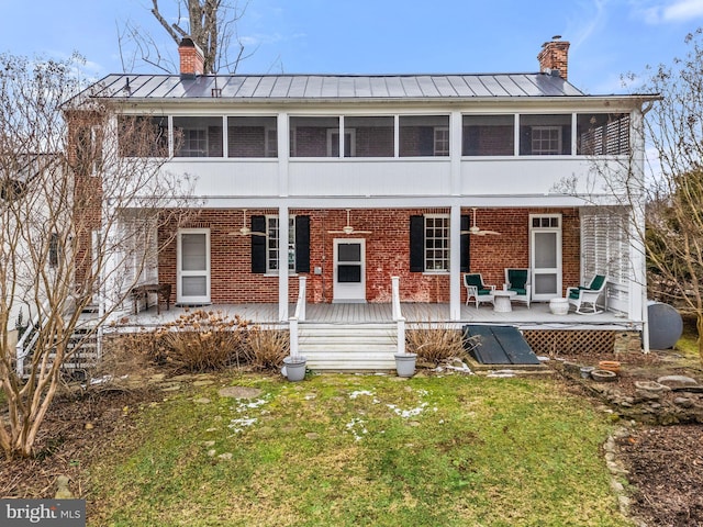 view of front of property with a wooden deck, a sunroom, and a front yard