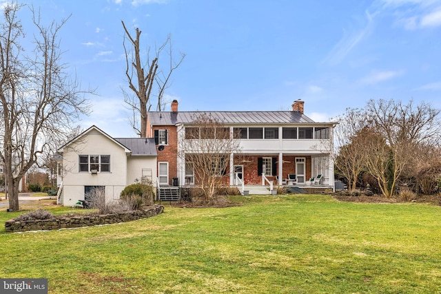 view of front facade with a front yard and a sunroom